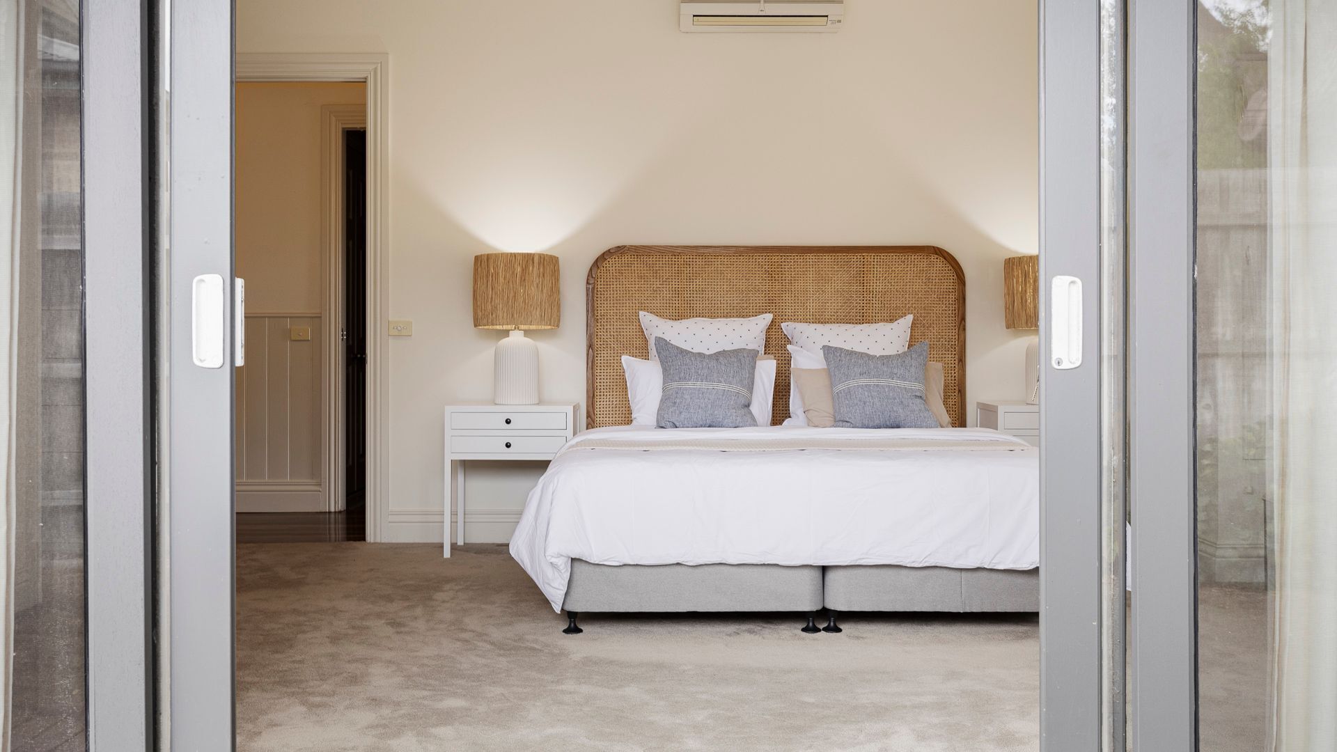 Un dormitorio con cama, mesita de noche y lámpara.