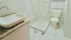 Un bagno con lavandino, WC e doccia.