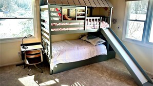 A bunk bed with a desk and chair, a window, and a view of trees. - Whaleback Retreat (Leland)