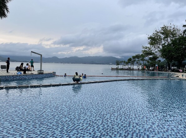 Una piscina al aire libre de temporada, sombrillas