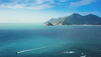Un paisaje costero con montañas, cielos despejados y mar tranquilo.