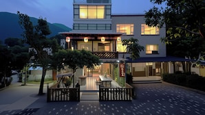 A modern hotel with a two-story structure, a covered outdoor seating area, and a view of the surrounding landscape. - Shenzhen Yusu Linting Inn (Shenzhen)