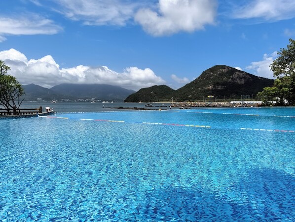 Una piscina al aire libre de temporada, sombrillas