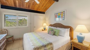 A bedroom with a bed, bedside tables, a chair, and a window with blinds.