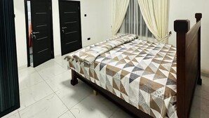 A bedroom with a bed, a ceiling fan, and an air conditioning unit. - Mankatiwa Court Apartmentnt (Weija)