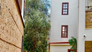 A narrow paved pathway flanked by buildings with a small garden area. - Adria Inn (Antalya)