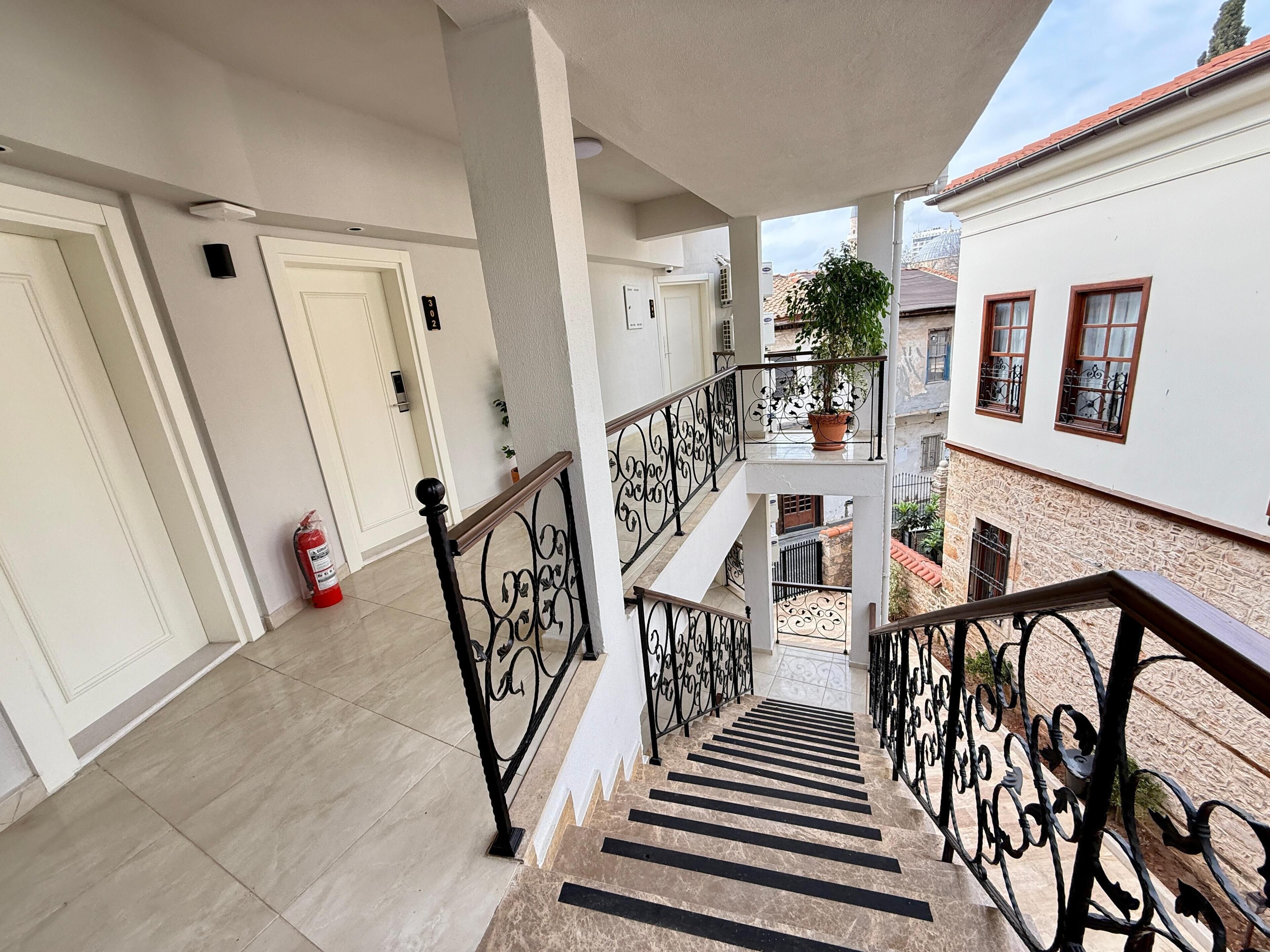 Un edificio residencial de varios niveles con escaleras, balcones y un extintor.