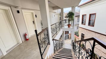 Un edificio residencial de varios niveles con escaleras, balcones y un extintor.