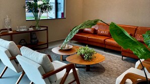 A modern living room with a sofa, chairs, a coffee table, and a large window. - Gran Amazon Av. Brasill (Belem)