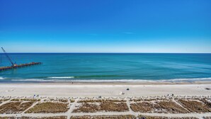 A beach with a pier extending into the ocean, sandy beach, and sparse vegetation in the foreground. - Ocean View Efficiency, Newly Renovated,Jacuzzi Tub (Myrtle Beach)