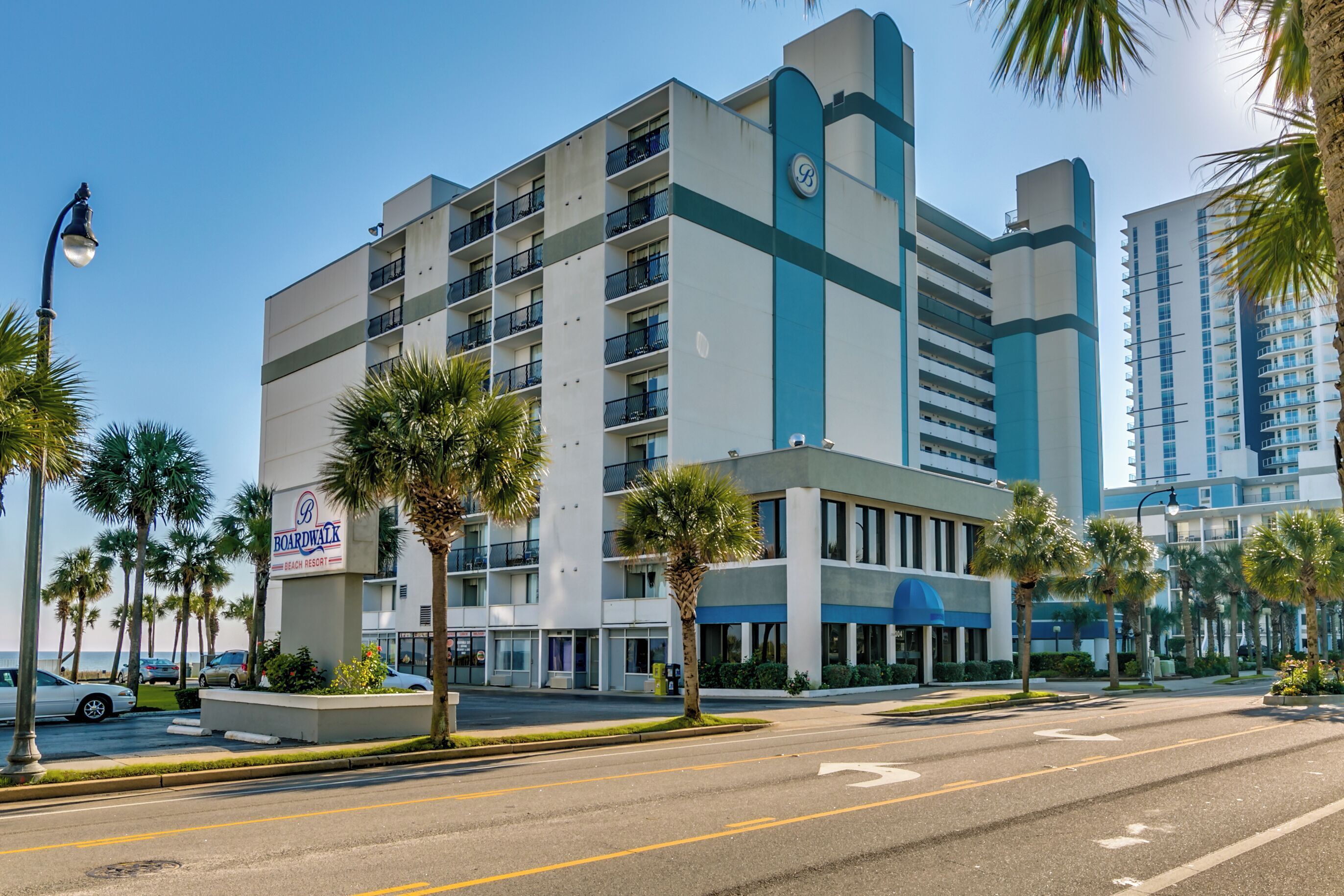 Et hotel i flere etager med skilt for Boardwalk Beach Resort, med altaner og et moderne arkitektonisk design.