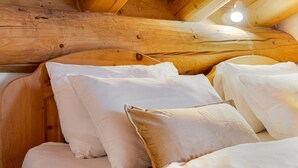 A cozy wooden cabin room with a bed, pillows, and a wooden ceiling. - Luxury chalet St. Moritz with panoramic mountain view (Madulain)