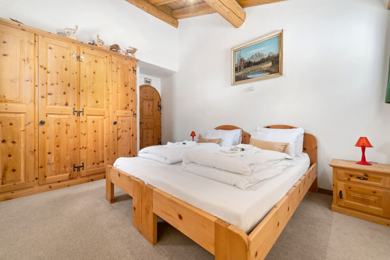 Ein Schlafzimmer mit einem hölzernen Bett, einem Nachttisch, einem Kleiderschrank und einem Bild an der Wand.