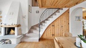A modern interior with a fireplace, wooden staircase, and a cozy seating area. - Luxury chalet St. Moritz with panoramic mountain view (Madulain)