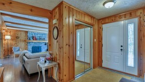 A cozy cabin interior with a stone fireplace, wooden walls, a sofa, and a dining area. - cozy family house for rent on the ski mountain (Saint-Sauveur)