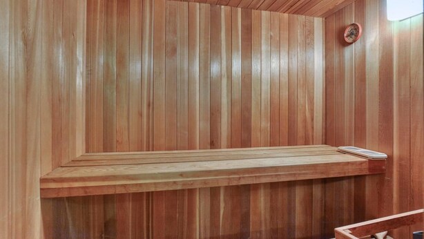 A wooden sauna with a bench and a wall-mounted heater. - cozy family house for rent on the ski mountain (Saint-Sauveur)