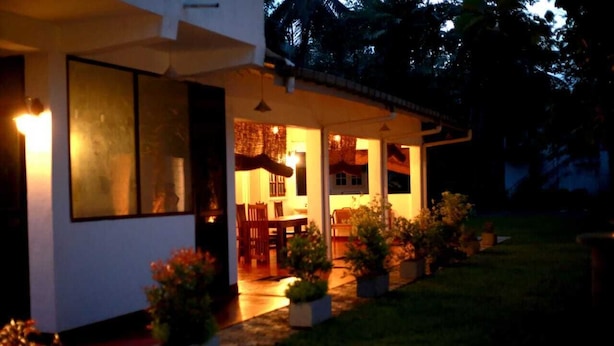 A house with a covered porch, a dining area, and potted plants. - Kithula (Talpe)