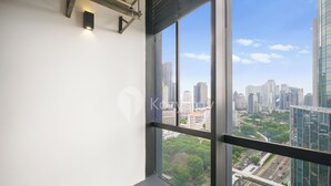 Une chambre située dans un immeuble de grande hauteur, dotée d’une grande fenêtre donnant sur le paysage urbain.