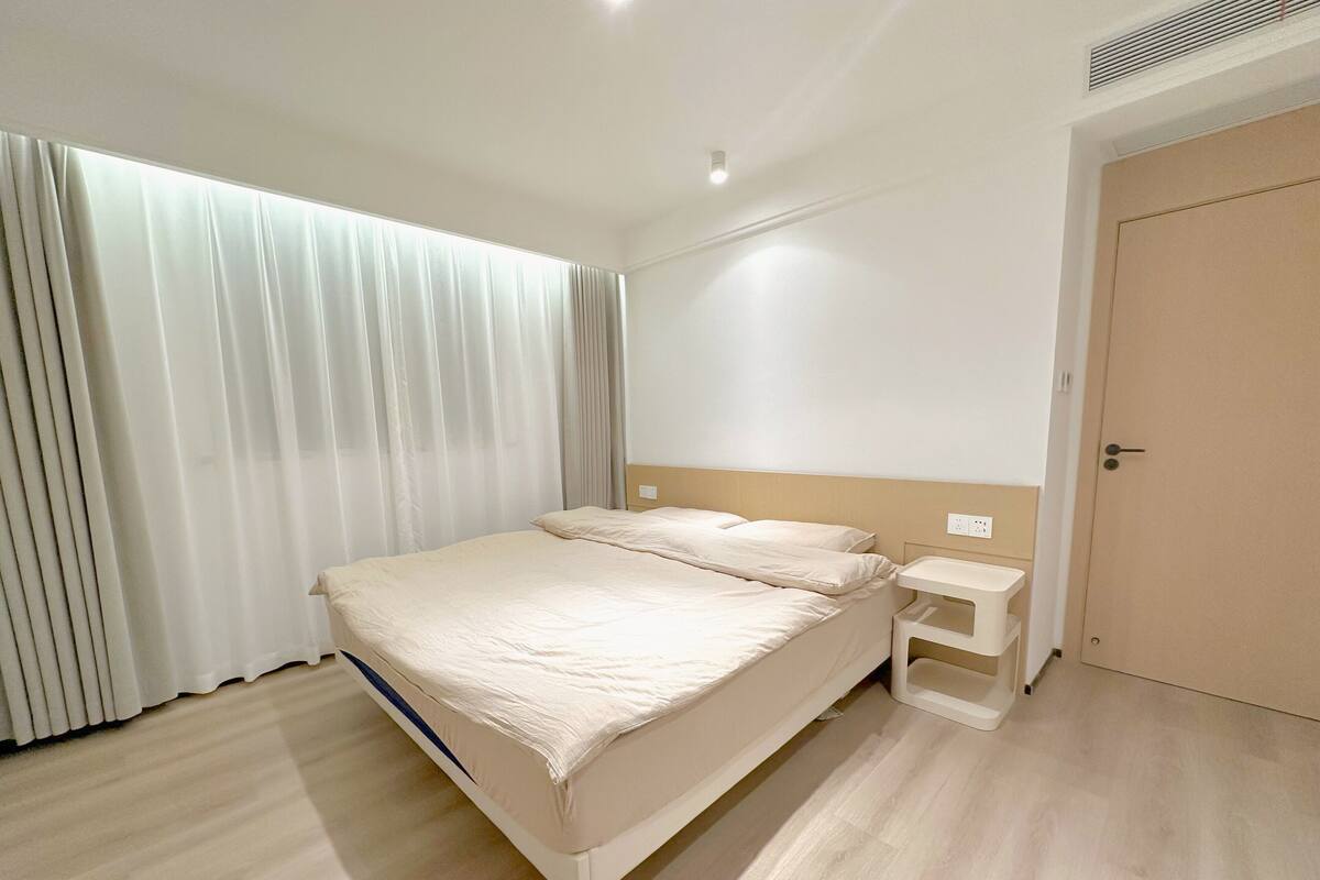 Une chambre à coucher moderne avec un lit, une table de chevet et une porte.