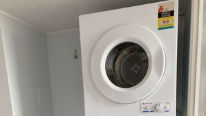 A compact laundry room with a wall-mounted washing machine, a small sink, and a dryer. - U07 Tripcony 2 Bedroom w Balcony (Sunshine Coast)