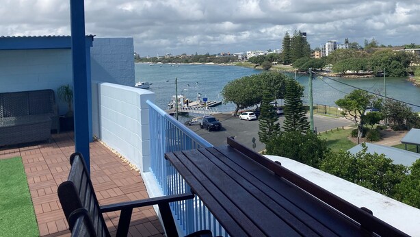 Un balcon donnant sur un port de plaisance, un pont et une étendue d’eau.