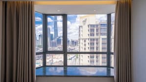 Habitació d'hotel amb un gran finestral que ofereix vista a la ciutat.
