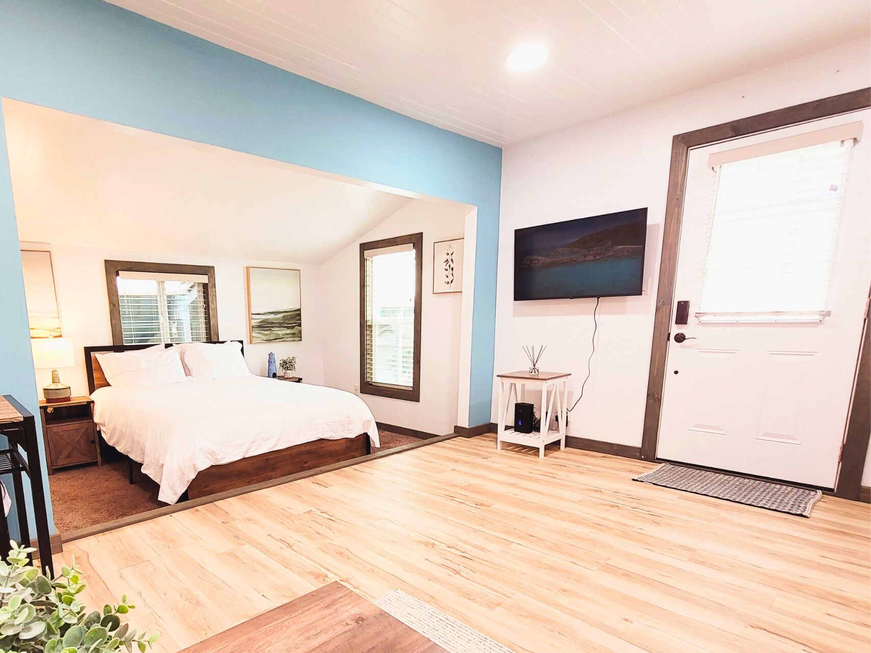 Una camera da letto con un letto, una televisione, un tavolino e una porta.