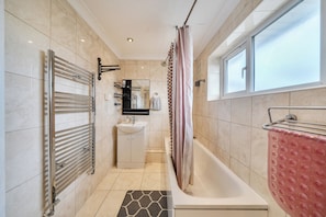 Ein modernes Badezimmer mit Badewanne, Dusche, Toilette und Waschbecken.