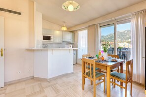 A modern kitchen with a microwave, oven, and a dining area with a table and chairs.