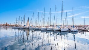 A marina with multiple sailboats docked, calm water, and a clear sky. - Coral House 2, Alghero, Italy (Alghero)
