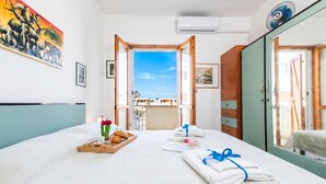 A hotel room with a bed, a breakfast tray, towels, a painting, and a view of the outside. - Coral House 2, Alghero, Italy (Alghero)