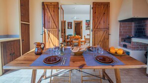 A wooden dining table set with plates, cutlery, and a bowl of oranges. - Coral House 2, Alghero, Italy (Alghero)