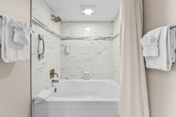 Un baño moderno con bañera, ducha e inodoro.