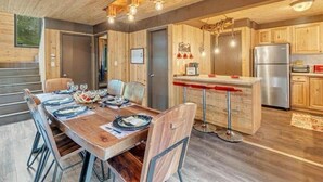 A wooden interior with a dining area, kitchen, and bar.