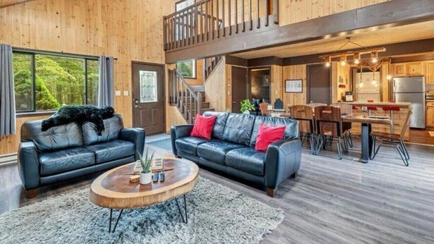 A spacious living area with a staircase, a dining area, and a kitchen.