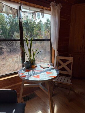 Relax in this serene room with a round table, potted plant, and comfortable chair.