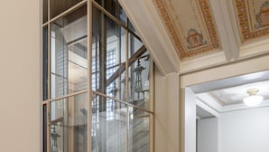 A staircase with ornate metal railings and a glass partition. - Renovated Loft in a Historical Downtown Building (Tampere)