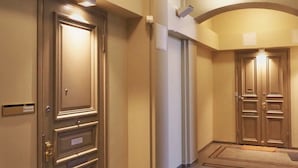 A hotel hallway with a carpeted floor, a door with a nameplate, and a ceiling with a decorative design. - Renovated Loft in a Historical Downtown Building (Tampere)