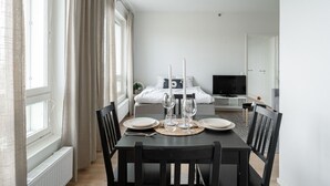 Ein modernes, minimalistisches Schlafzimmer mit Bett, Nachttisch und Fernseher.