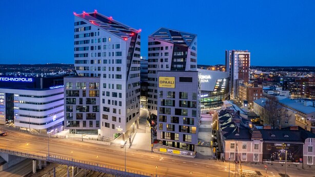 Un moderno paisaje urbano con edificios destacados, incluyendo un casino y un centro tecnológico.