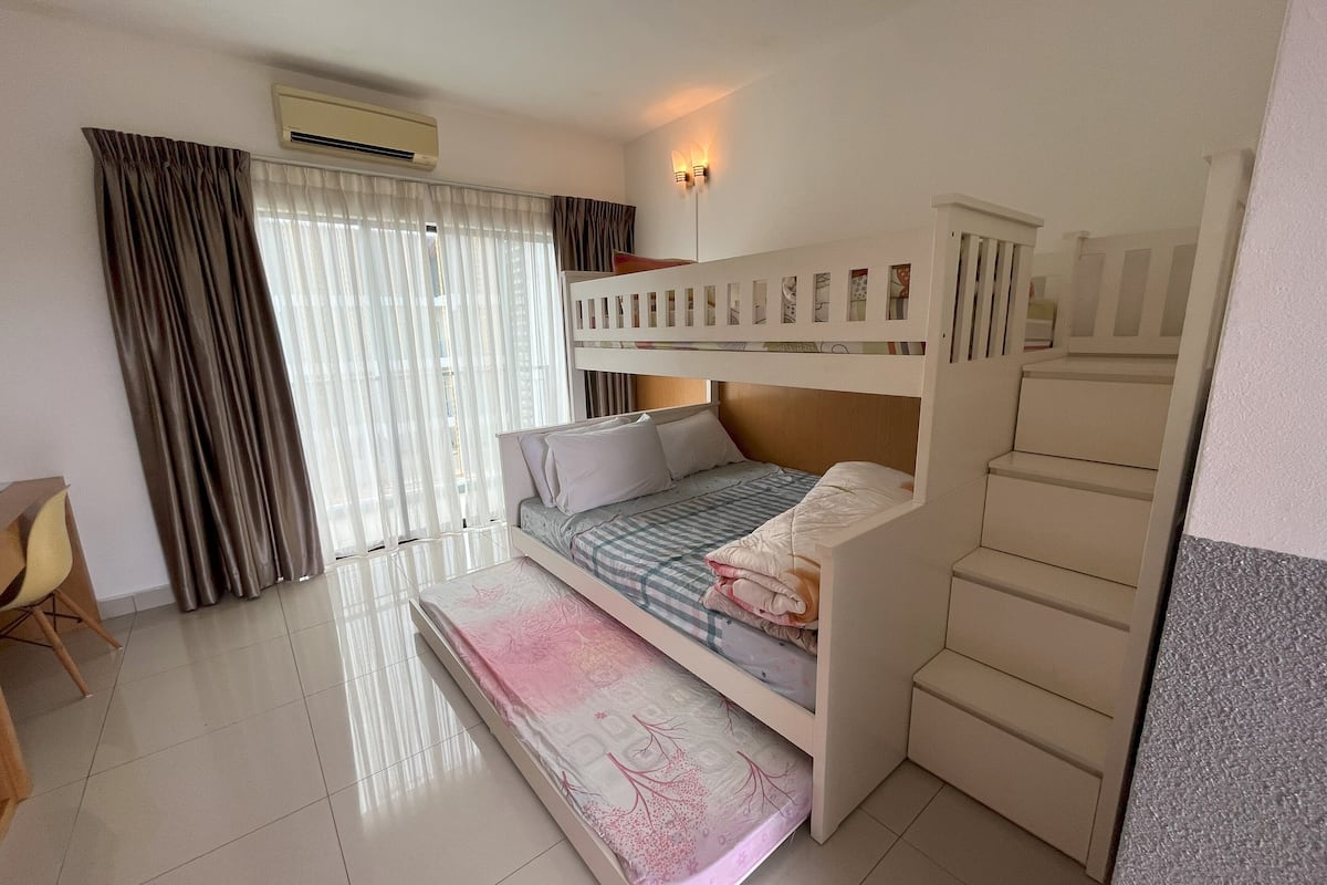 A room with a bunk bed, a desk, and a chair.