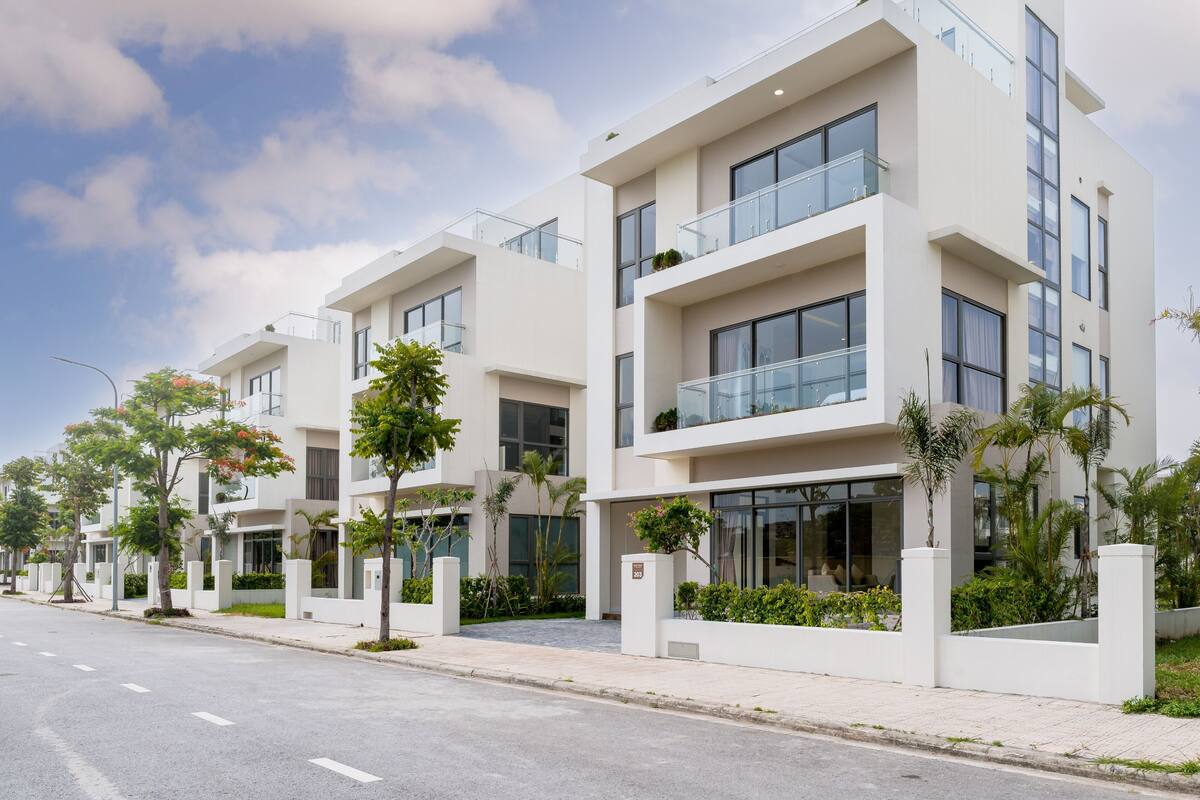 A modern multi-story residential building with balconies and large windows.