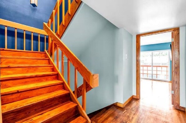 A wooden staircase leading to a balcony with a view of a fence. - A. Houston Resort Style Pool - EV Charging (Houston)