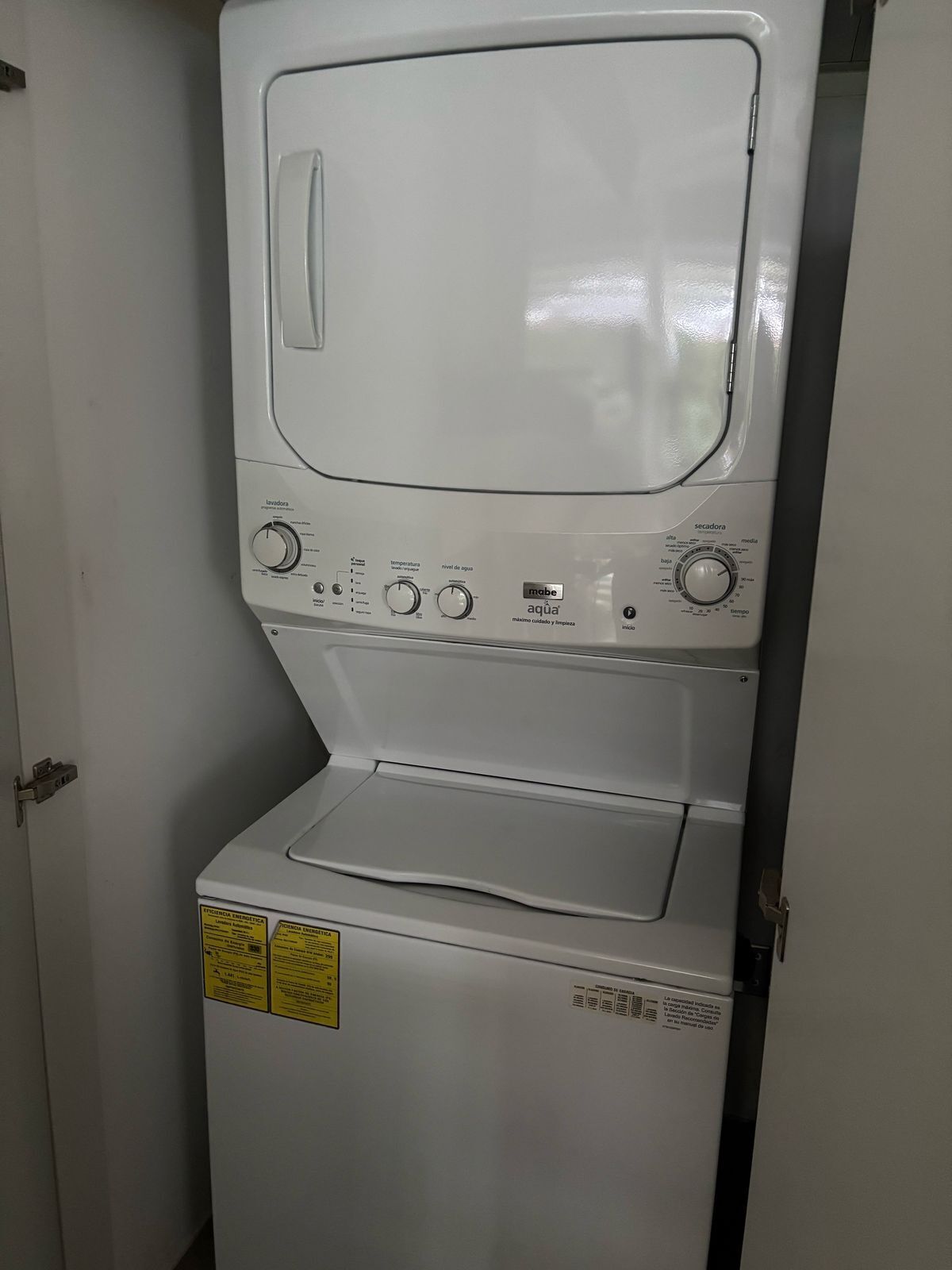 Une machine à laver à chargement frontal, dotée de boutons de commande et d’un distributeur de détergent.