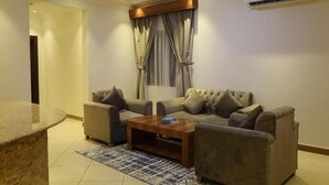A modern living room with two sofas, a coffee table, and a stone accent piece. - rukn albahiat lilshuqaq almakhduma (Riyadh)