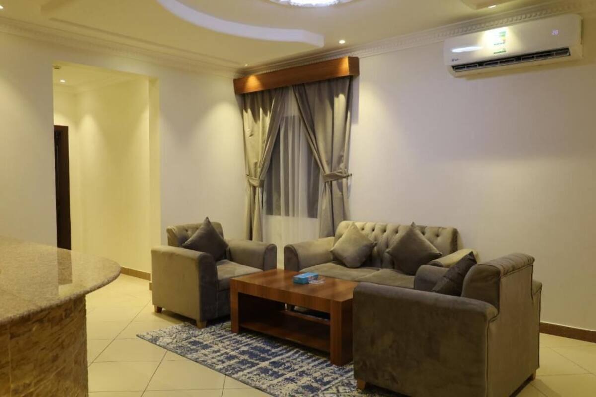 A modern living room with two sofas, a coffee table, and a stone accent piece.