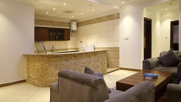 A modern living room with a stone island and a sofa. - rukn albahiat lilshuqaq almakhduma (Riyadh)