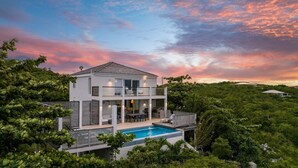 A modern two-story house with a swimming pool, surrounded by lush greenery. - Villa TreeHaus: Paradise Overlooking Grace Bay (Caicos Islands)