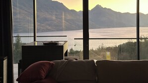 A room with a large window offering a view of mountains and a lake. - 1Queenstown - Stunning Lake and Mountain Views (Queenstown)