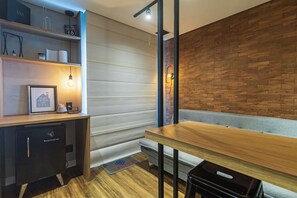 Un interior moderno con una mesa de madera, un banco y una pared de ladrillo.